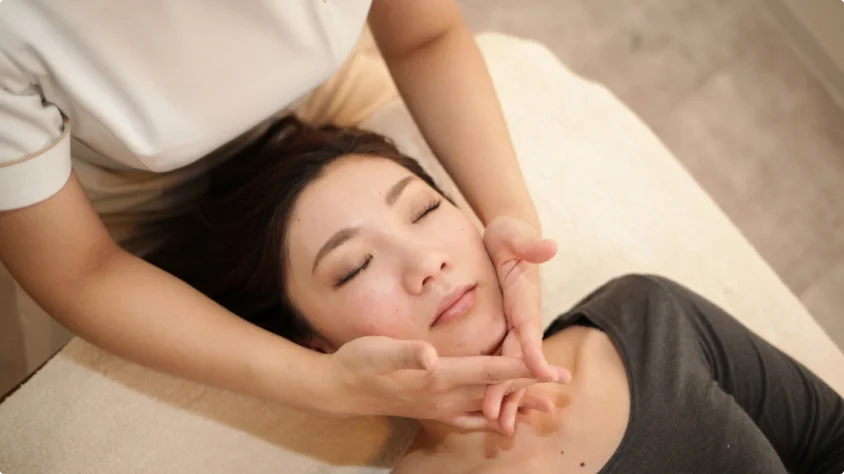 顔まわりのハンドトリートメントを受ける女性