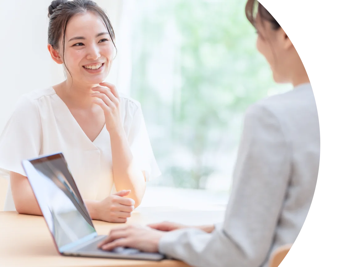 ノートパソコンを前に、笑顔で対話する女性