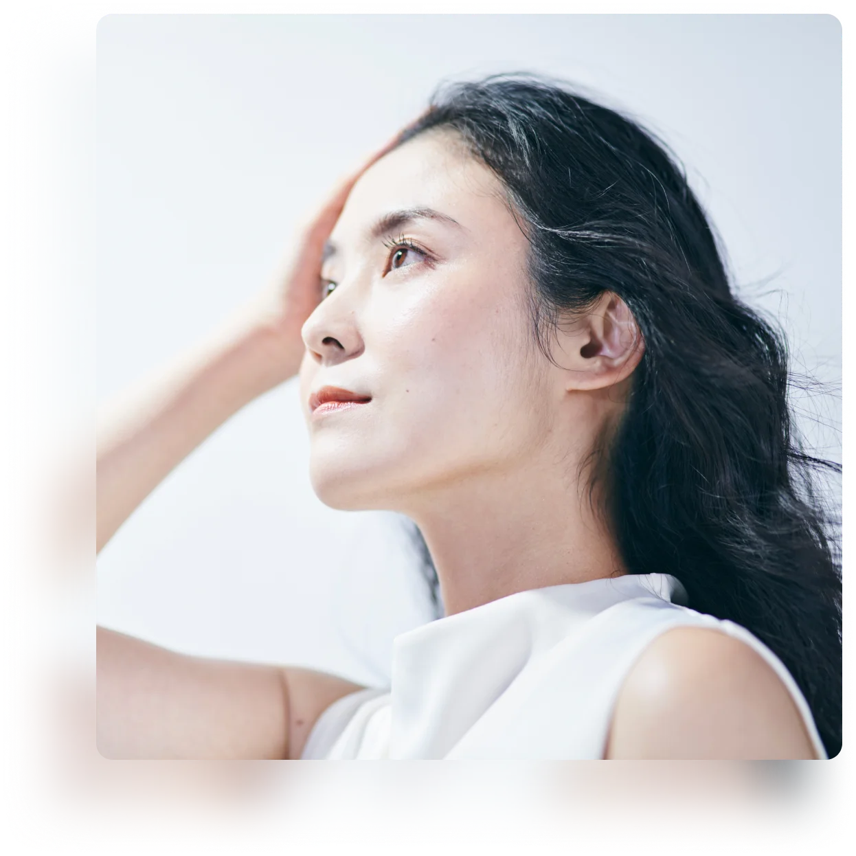髪に手を添え、横を見つめる女性